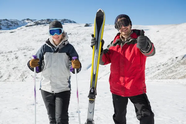 Portrait of a smiling couple with ski equipment on snow — Stock Photo, Image