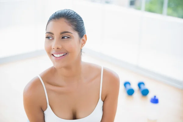 Gelukkig afgezwakt brunette zittend op de vloer — Stockfoto