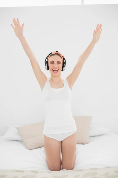 Woman raising her arms while listening to music — Stock Photo, Image