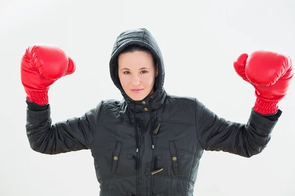 Lächelnde schöne Frau mit Kapuze und roten Boxhandschuhen — Stockfoto