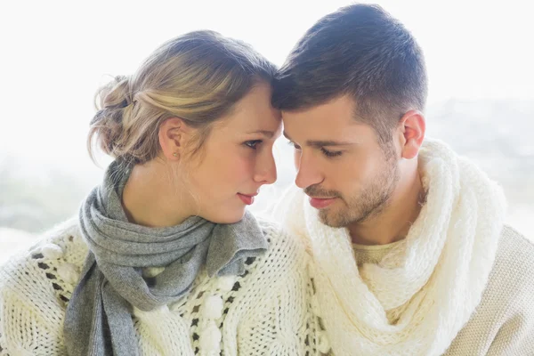 Casal amoroso em roupas de inverno contra fundo brilhante — Fotografia de Stock