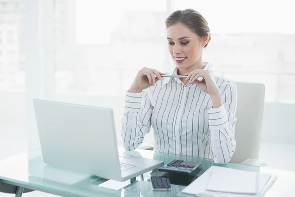 Attraktiva chic affärskvinna hålla en penna som sitter vid hennes skrivbord — Stockfoto