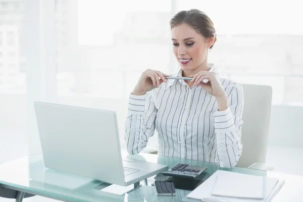 Aantrekkelijke chique zakenvrouw houden een potlood zit op haar Bureau — Stockfoto