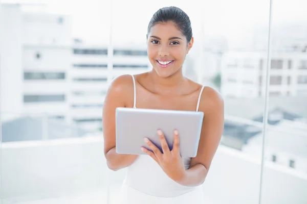 Alegre tonificado morena celebración de la tableta — Foto de Stock