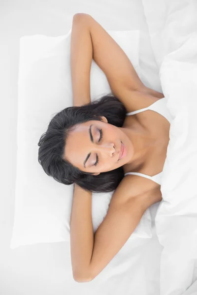 Мирная молодая женщина спит лежа на кровати — стоковое фото