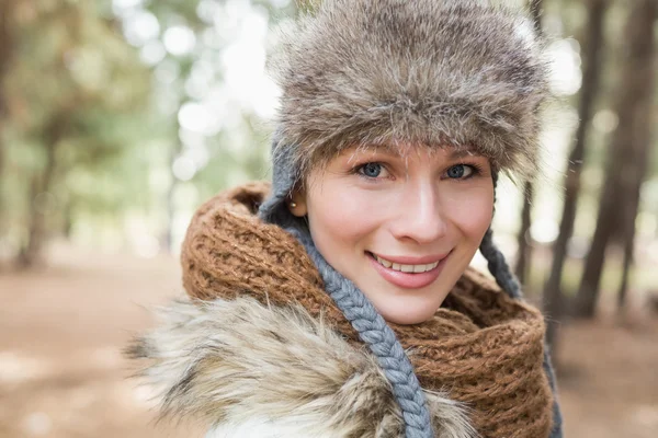 Kvinna i pälsmössa med ull halsduk i skogen — Stockfoto