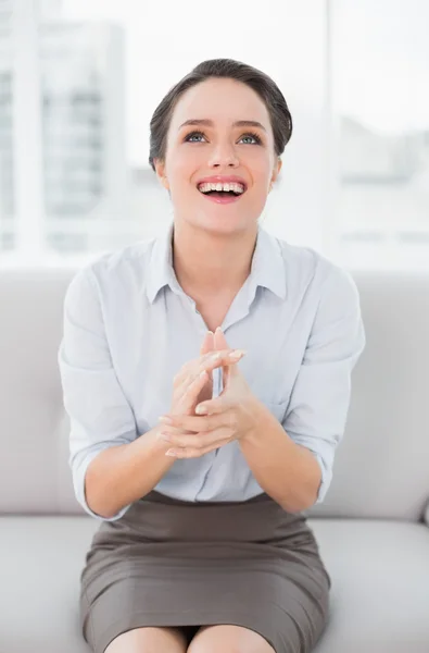 Smiling well dressed woman applauding while looking up — Stock Photo, Image