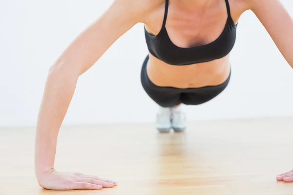 Mid section of a sporty woman doing push ups — Stock Photo, Image