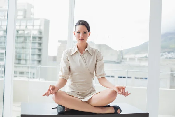 Femme d'affaires intelligente assise en position de lotus au bureau — Photo