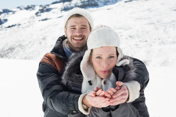 Пара с чашечками рук на снежном пейзаже — стоковое фото