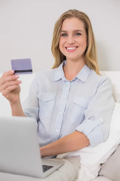 Cheerful casual blonde relaxing on couch doing online shopping — Stock Photo, Image