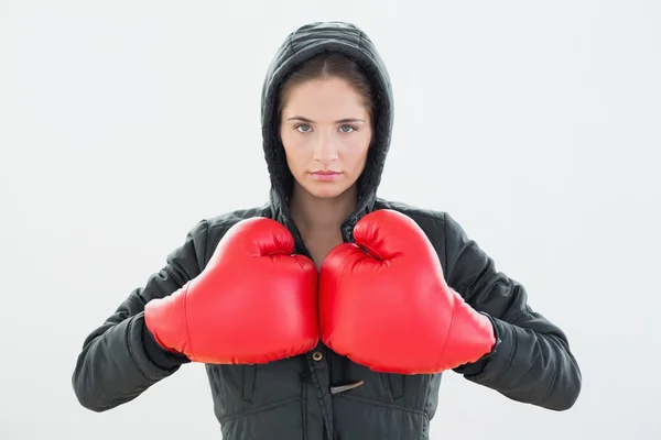 Mujer joven seria con guantes de boxeo rojos y capucha negra —  Fotos de Stock