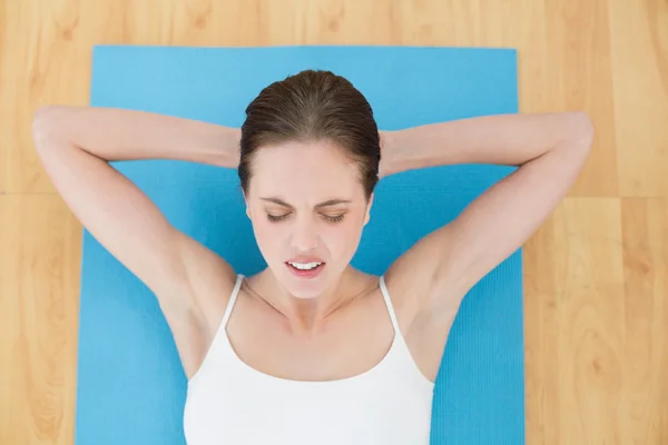 Frau ruht mit geschlossenen Augen auf Gymnastikmatte — Stockfoto
