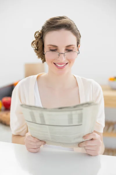 Beautiful young woman wearing glasses for reading newspaper — Stock Photo, Image