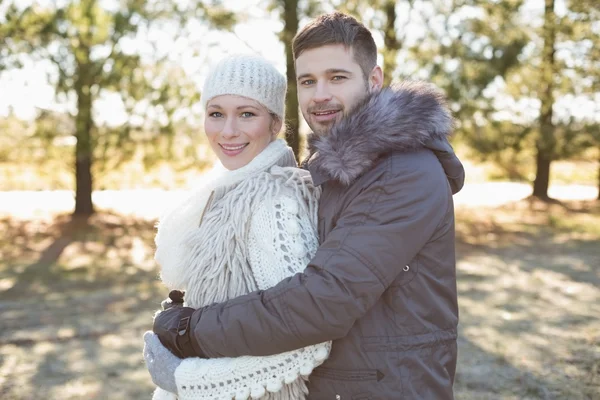 Loving young couple in winter clothing in the woods — Stock Photo, Image