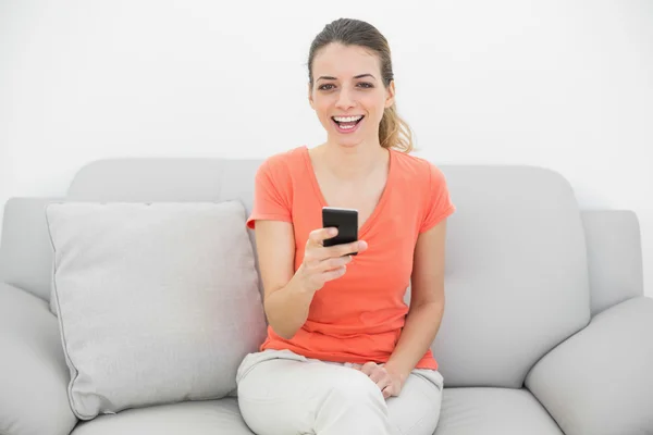 Mujer tranquila alegre riendo sosteniendo su teléfono inteligente — Foto de Stock