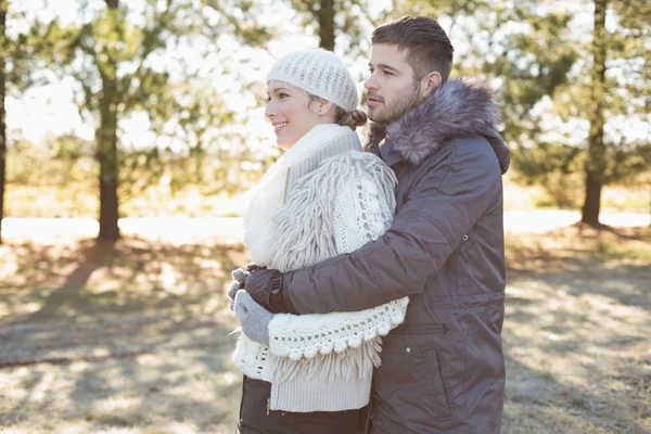 Amante jovem casal em roupas de inverno na floresta — Fotografia de Stock