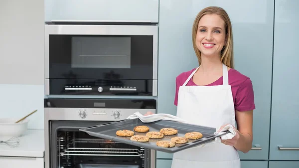 Mujer contenido casual sosteniendo bandeja para hornear con galletas —  Fotos de Stock