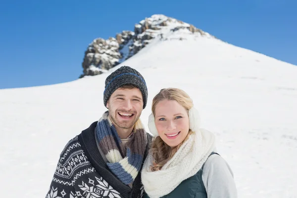 Paar vor verschneitem Hügel und strahlend blauem Himmel — Stockfoto