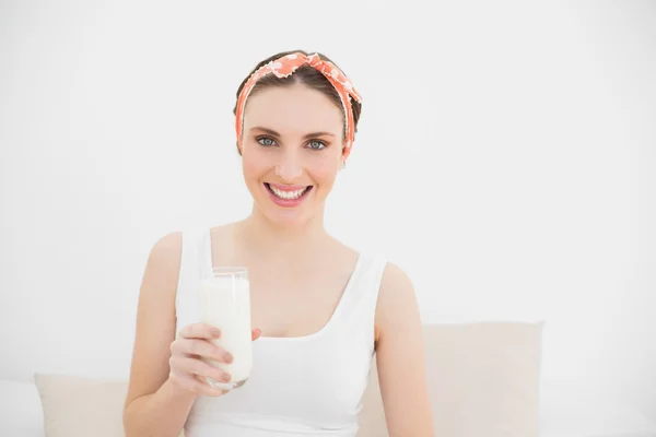 Femme souriante tenant un verre de lait — Photo