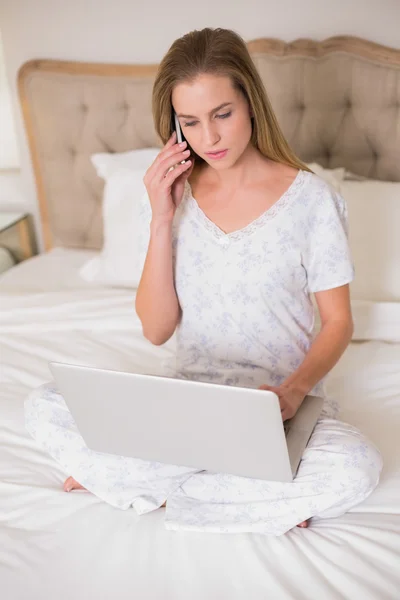 Donna calma naturale utilizzando laptop e telefono — Foto Stock