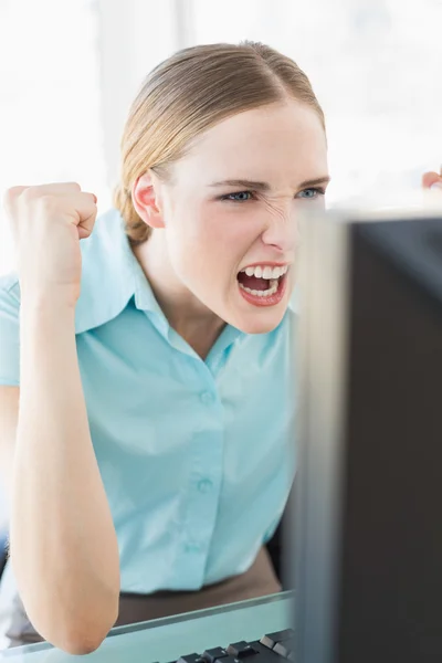 Классическая возбужденная деловая женщина, сидящая перед компьютером — стоковое фото