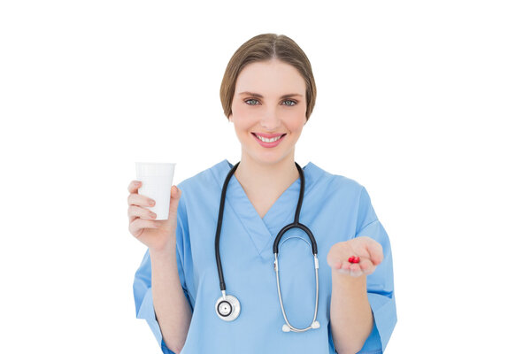 Женщина-врач с пластиковой чашкой и красными таблетками
