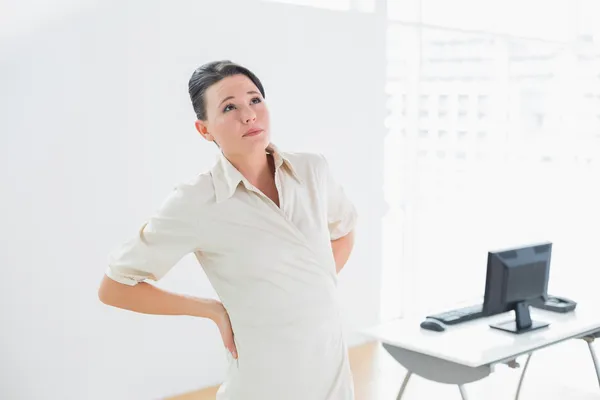 Zakenvrouw die lijden aan rugpijn in office — Stockfoto