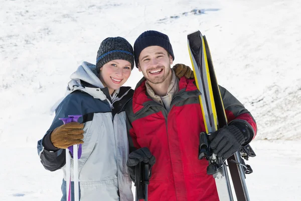 Retrato de una pareja sonriente con tablas de esquí en la nieve —  Fotos de Stock