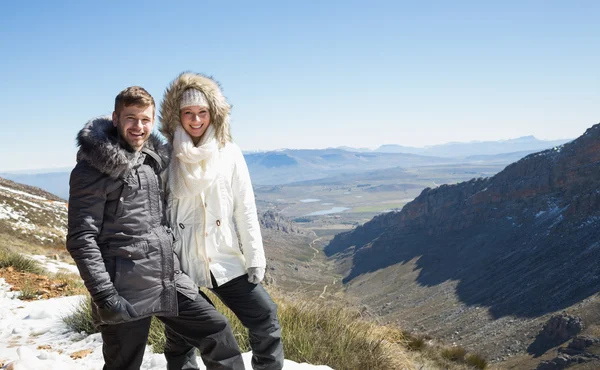 Pareja en chaquetas capucha de piel contra el valle montañoso nevado — Foto de Stock