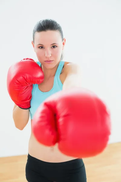 Mooie vrouw in rode bokshandschoenen op fitness-studio — Stockfoto