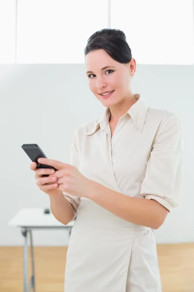 Femme d'affaires avec téléphone portable au bureau — Photo