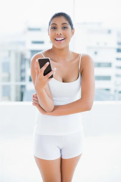 Cheerful toned brunette holding smartphone — Stock Photo, Image