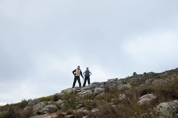 Paar steht auf felsiger Landschaft vor klarem Himmel — Stockfoto