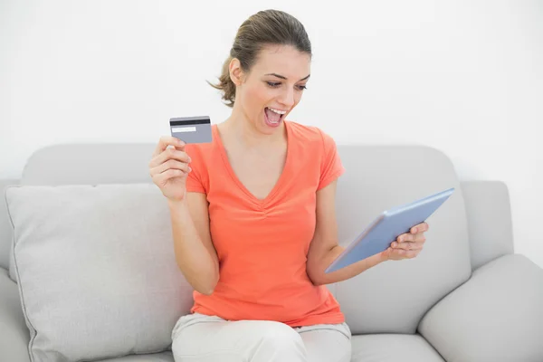Ελκυστική γυναίκα δείχνει την πιστωτική κάρτα που κρατά το δισκίο — Φωτογραφία Αρχείου