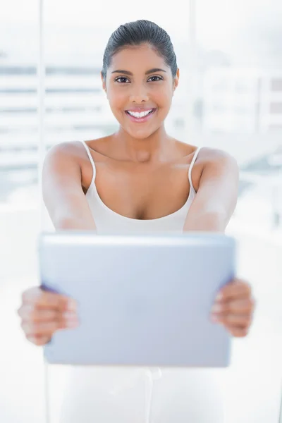 Happy toned brunette holding tablet — Stock Photo, Image