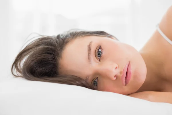 Portret van een mooie jonge vrouw in bed — Stockfoto