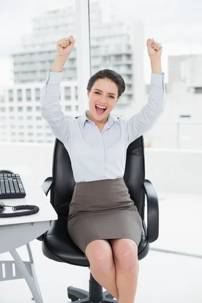 Elegant and happy businesswoman clenching fists in office — Stock Photo, Image