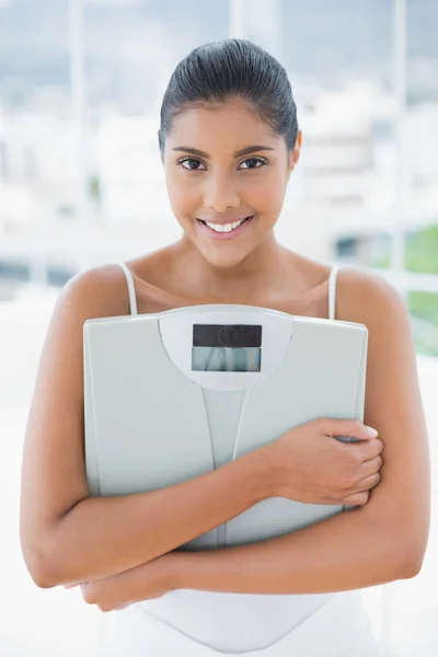 Sonriente morena tonificada sosteniendo escamas — Foto de Stock