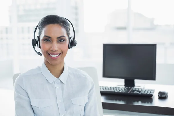 Attractive female agent wearing headset smiling at camera — Stock Photo, Image