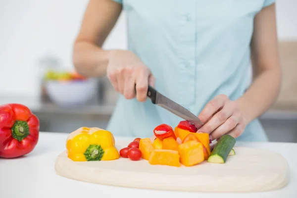 Mitten delen av ung smal kvinna skära grönsaker — Stockfoto