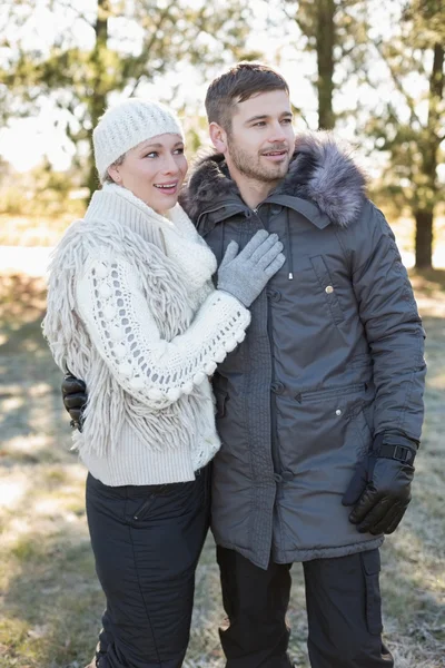 Amar a la joven pareja en ropa de invierno en el bosque —  Fotos de Stock
