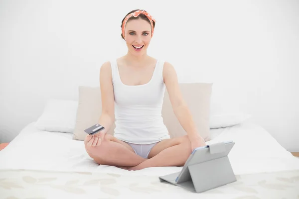 Mujer joven sonriente usando su tableta mirando a la cámara — Foto de Stock