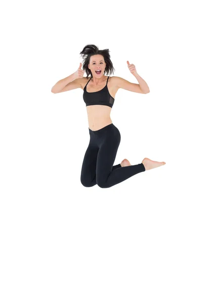Sportlich aktive junge Frau gestikuliert mit erhobenem Daumen — Stockfoto