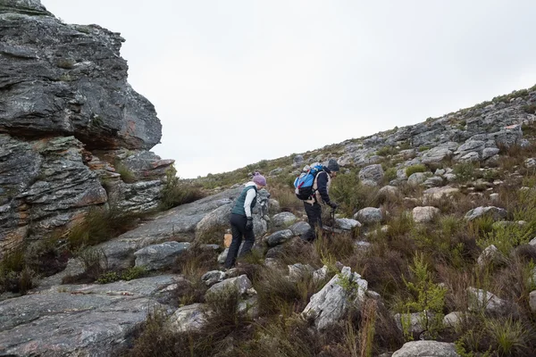 Couple walking through rocky landscape against clear sky — Stock Photo, Image