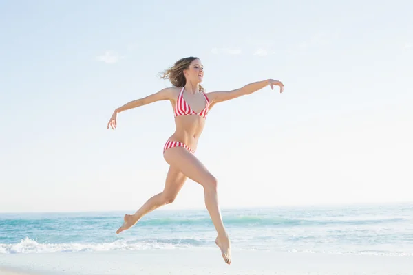 Mooie blonde vrouw springen op het strand — Stockfoto