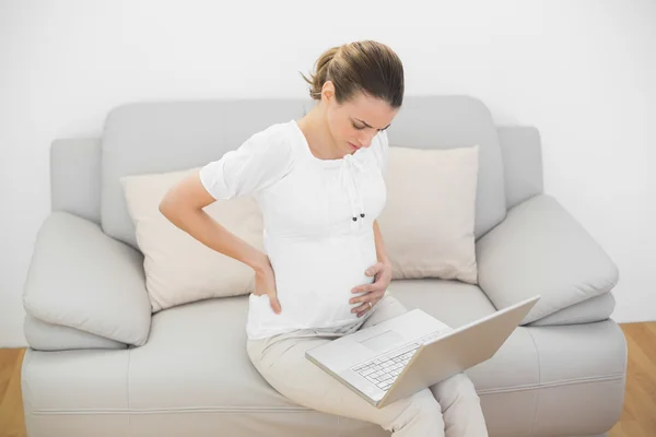 Serious pregnant woman touching her injured back — Stock Photo, Image