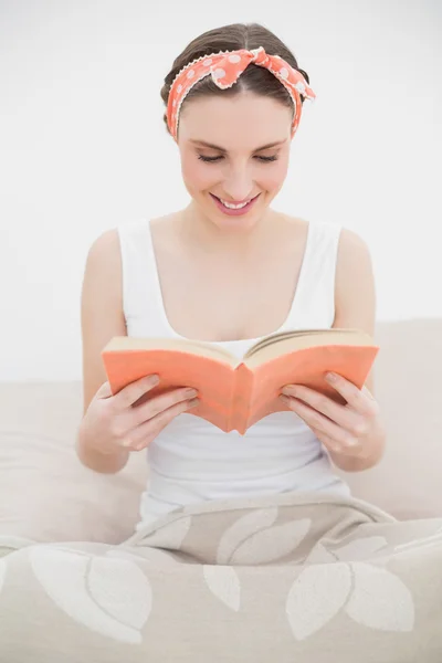 Glimlachende jonge vrouw die een boek leest — Stockfoto