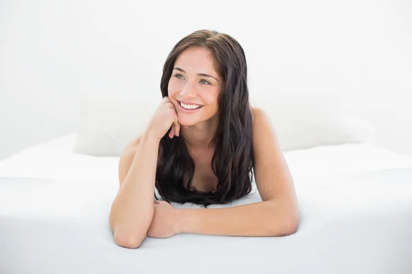 Glad kvinna tittar bort i sängen — Stockfoto