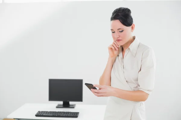 Geschäftsfrau schaut im Büro auf Handy — Stockfoto